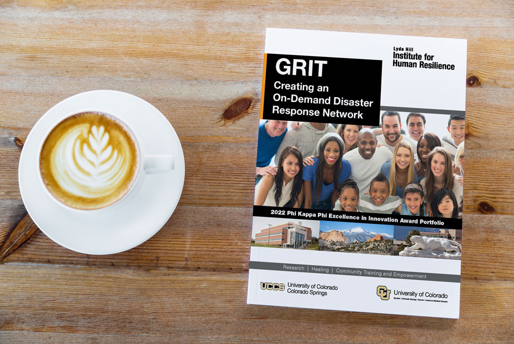 Photo of the GRIT Portfolio sitting on a table with a cup of coffee