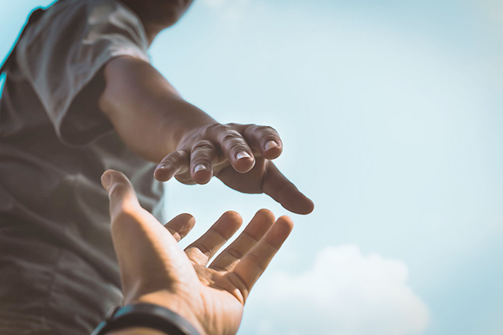 Man's hand reaching out to help another person