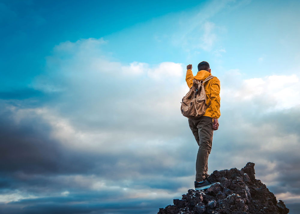 Man standing at the top of a mountain