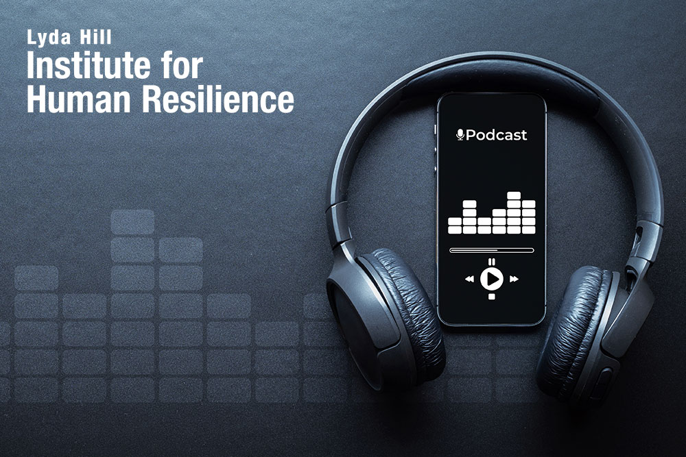 Photo of headphones and a phone playing a podcast with the Lyda Hill Institute for Human Resilience logo