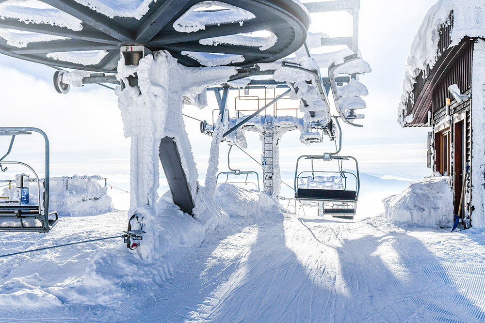 Snowy ski lift at the top of a mountain