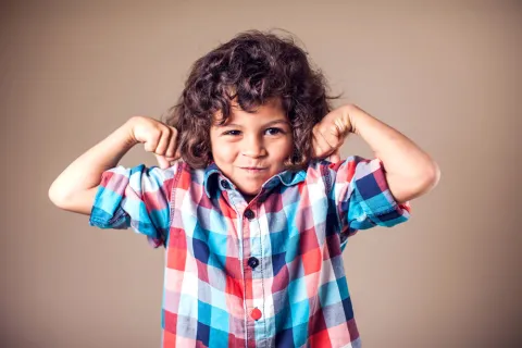 Child flexing his muscles 