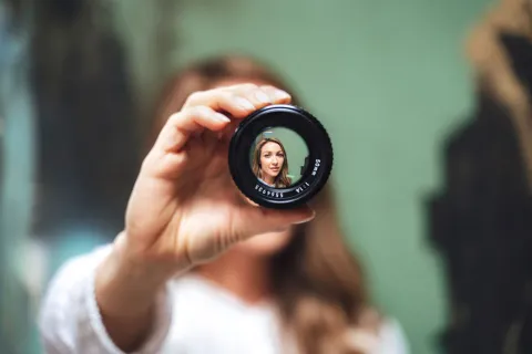 Woman looking through a camera lens