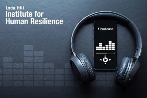 Photo of headphones and a phone playing a podcast with the Lyda Hill Institute for Human Resilience logo