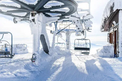 Snowy ski lift at the top of a mountain