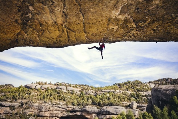a climber hangs from a sheer rock
